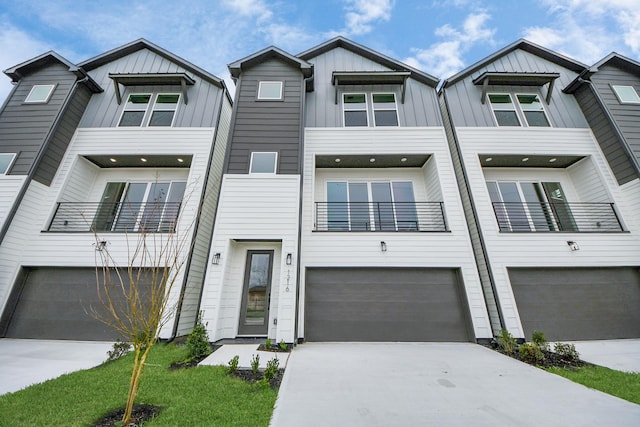 townhome / multi-family property featuring board and batten siding, an attached garage, and driveway