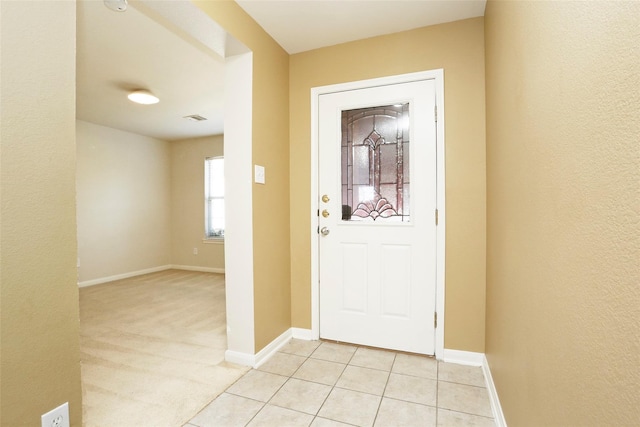 entrance foyer featuring light colored carpet, light tile patterned floors, baseboards, and visible vents