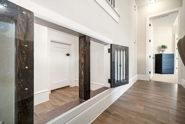 hall featuring wood finished floors and baseboards