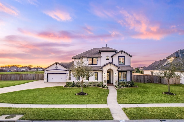 view of front of property with fence, an attached garage, stucco siding, concrete driveway, and a lawn