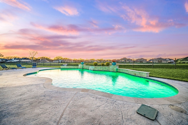 pool at dusk with a fenced in pool, a patio, a yard, and a fenced backyard