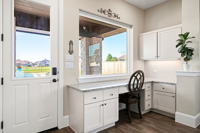 office featuring baseboards, dark wood-style floors, and built in study area