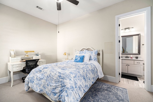 carpeted bedroom featuring visible vents, baseboards, ensuite bath, and a ceiling fan