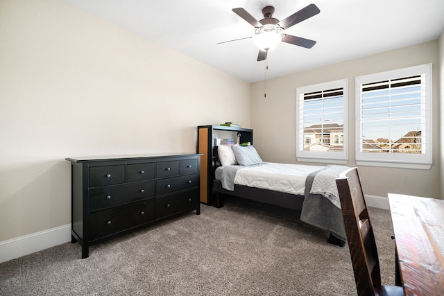 bedroom featuring light colored carpet, a ceiling fan, and baseboards