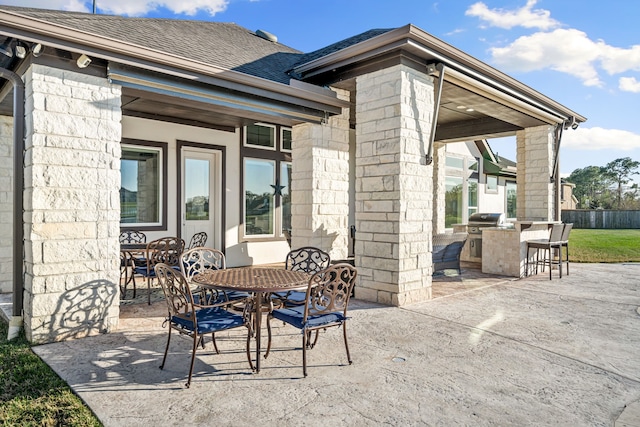 view of patio / terrace featuring outdoor dining area, area for grilling, outdoor dry bar, and fence