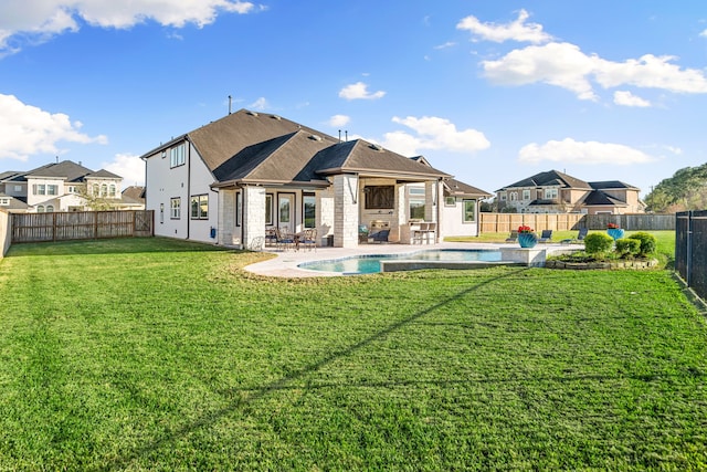 rear view of property featuring a patio area, a yard, a fenced backyard, and a fenced in pool