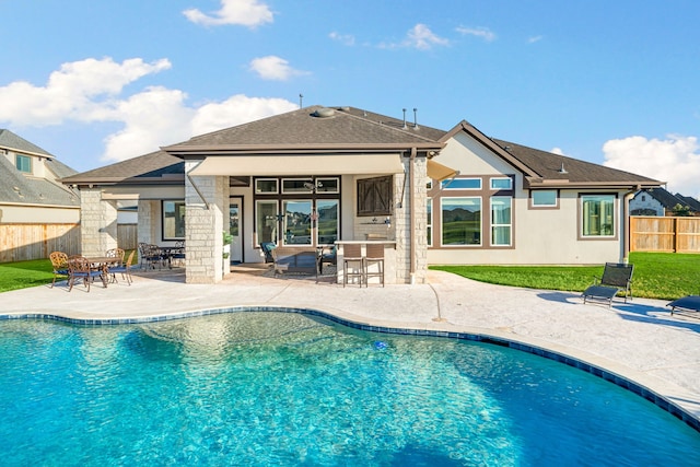 view of swimming pool with outdoor dry bar, a fenced in pool, a patio, and fence