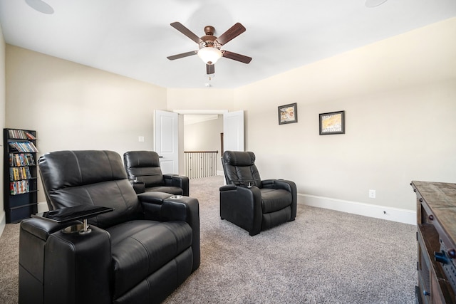 carpeted cinema room featuring baseboards and ceiling fan