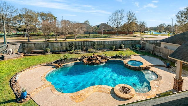 view of swimming pool featuring a yard, a fenced backyard, and a pool with connected hot tub