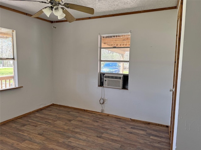 unfurnished room featuring a textured ceiling, a healthy amount of sunlight, dark wood-style floors, and a ceiling fan