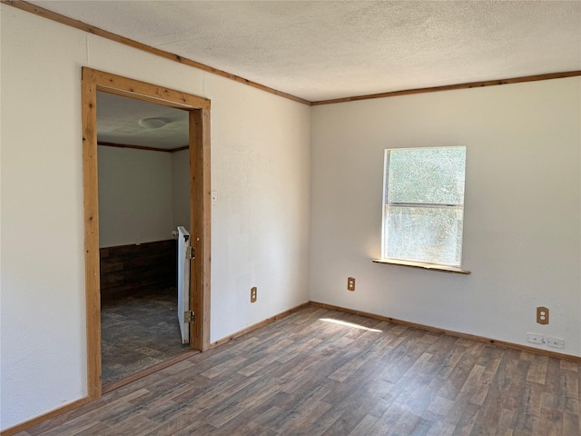 unfurnished room featuring a textured ceiling, crown molding, and wood finished floors