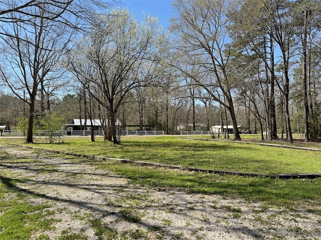 view of property's community with a lawn and fence