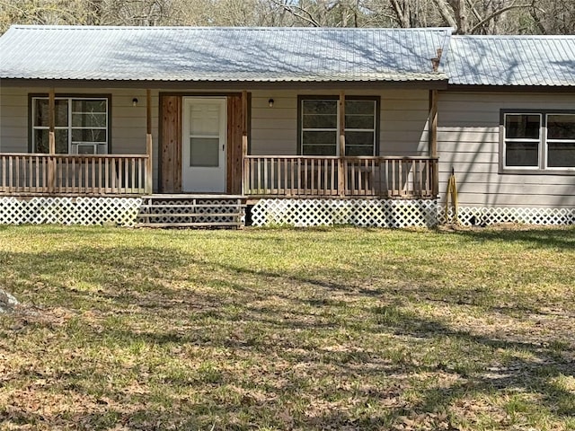 ranch-style home with a front yard, a porch, and metal roof