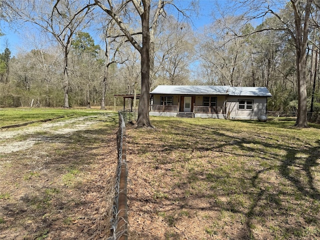 view of front of house with a porch, a front lawn, and metal roof