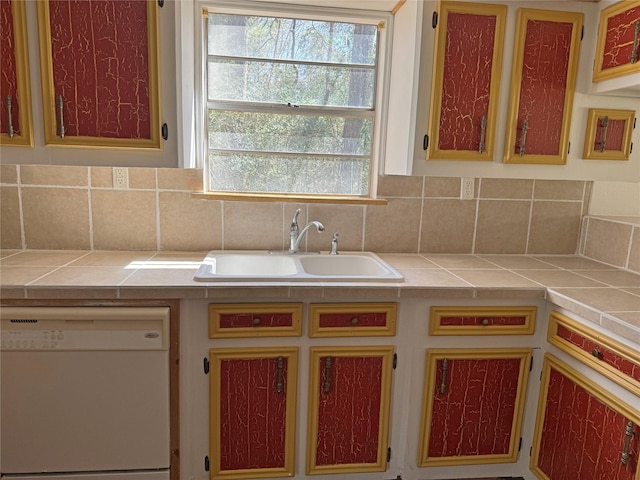 kitchen with decorative backsplash, tile countertops, dishwasher, and a sink