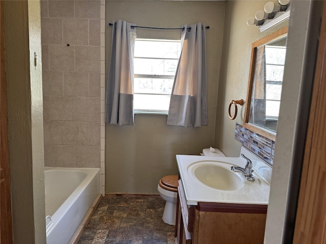 bathroom with stone finish floor, toilet, and vanity