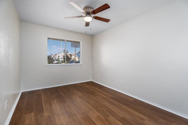 spare room featuring ceiling fan, baseboards, and wood finished floors