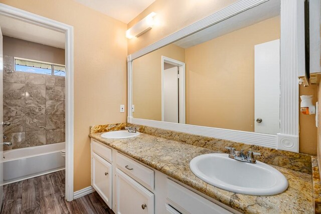 bathroom featuring double vanity, toilet, wood finished floors, and a sink