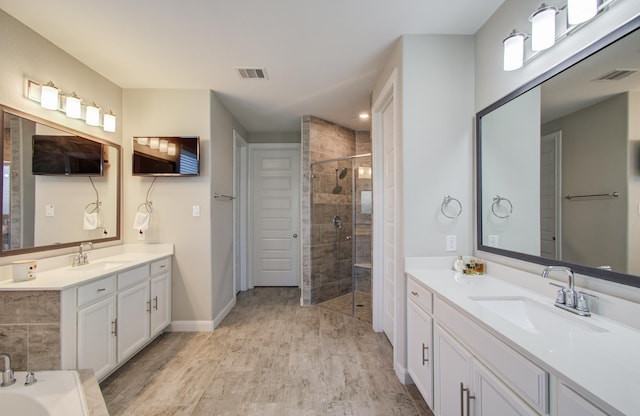 full bath with a sink, visible vents, wood finished floors, and a shower stall