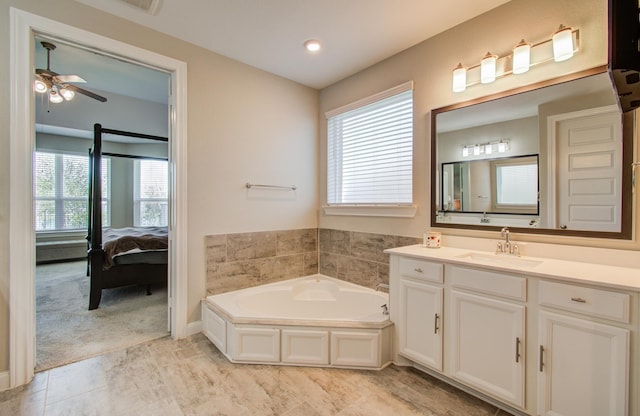 bathroom featuring vanity, a healthy amount of sunlight, a bath, and ensuite bathroom