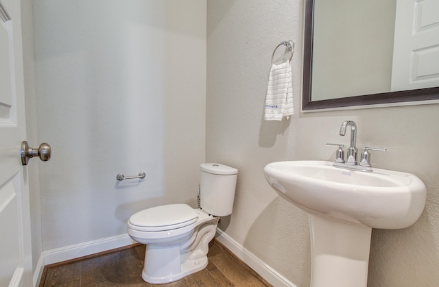 bathroom featuring toilet, wood finished floors, and baseboards