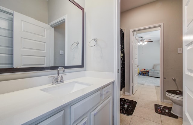 bathroom with tile patterned floors, toilet, vanity, and a ceiling fan