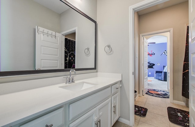 full bath featuring vanity, baseboards, and tile patterned flooring