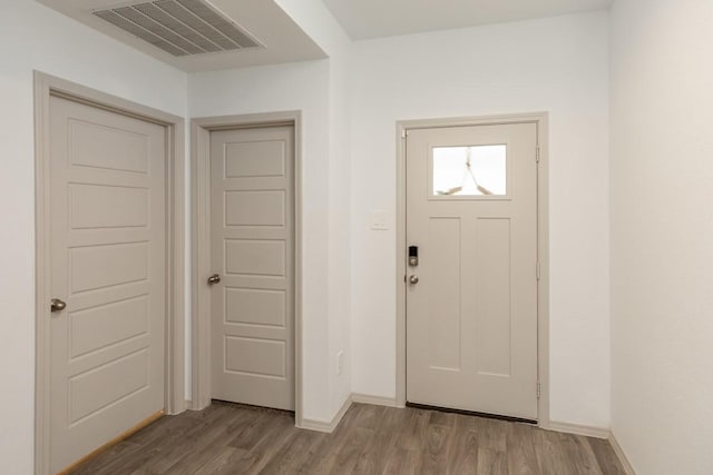 entrance foyer with visible vents, baseboards, and wood finished floors