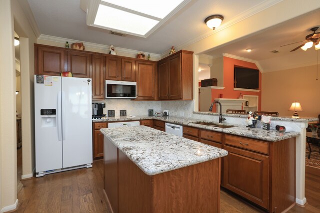9407 Thurber Ridge Dr, Spring, TX 77379 - kitchen featuring white appliances, a sink, a peninsula, light stone countertops, and ornamental molding