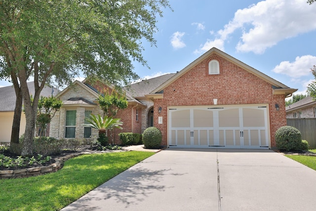 9407 Thurber Ridge Dr, Spring, TX 77379 - view of front of home with driveway, a garage, brick siding, and a front yard