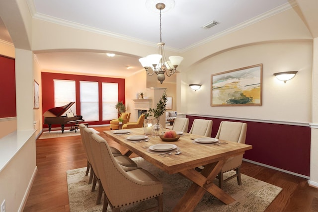 9407 Thurber Ridge Dr, Spring, TX 77379 - dining room with arched walkways, ornamental molding, wood finished floors, a chandelier, and baseboards