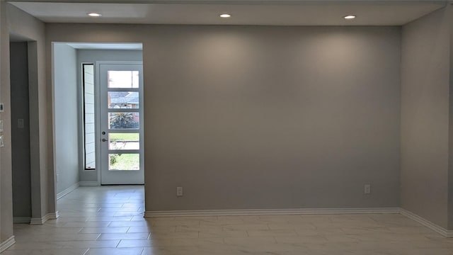 empty room featuring recessed lighting and baseboards