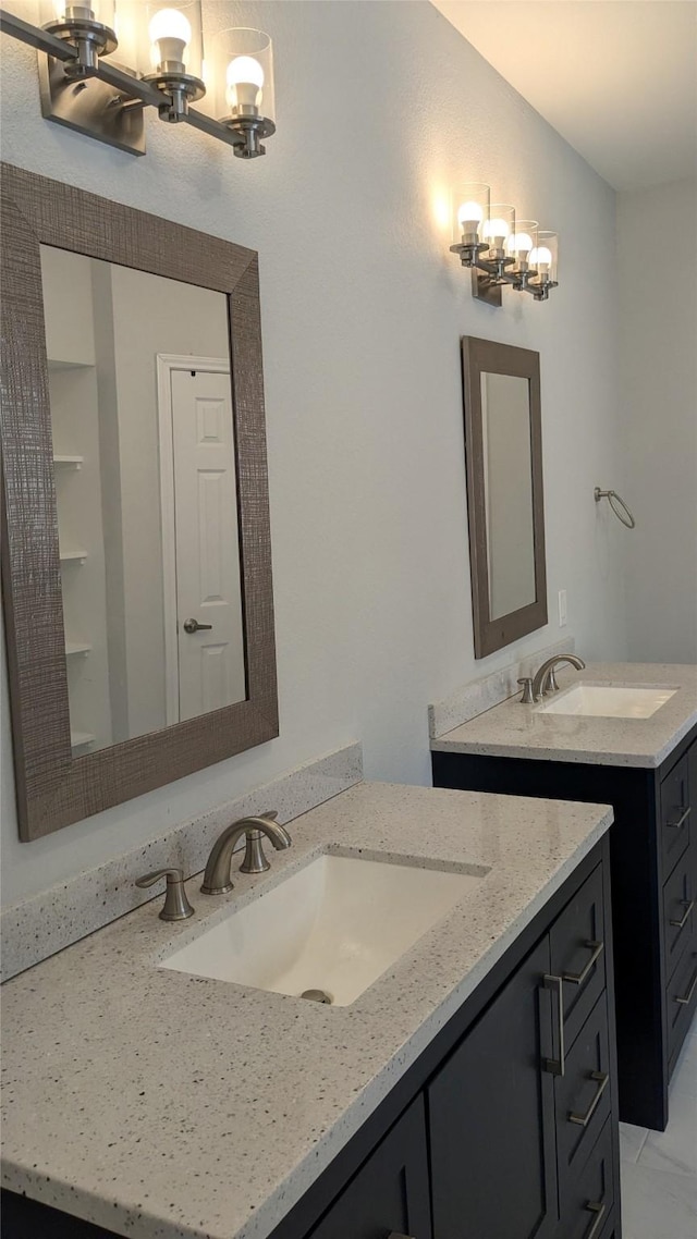 bathroom with an inviting chandelier, vanity, and vaulted ceiling