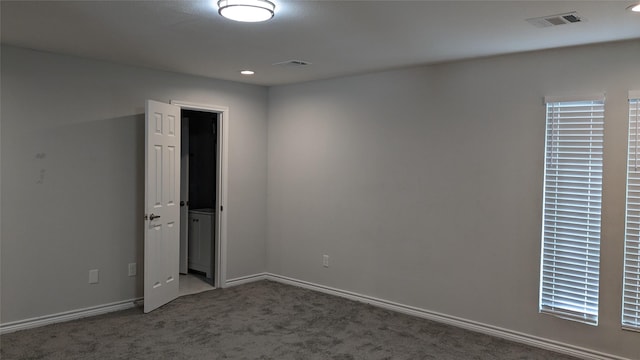 carpeted empty room featuring visible vents and baseboards