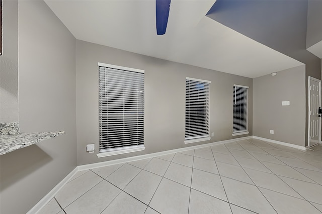 unfurnished room with light tile patterned floors, baseboards, and ceiling fan