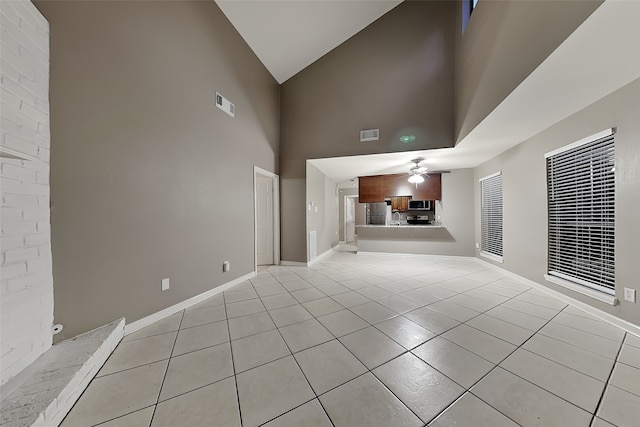 unfurnished living room with light tile patterned floors, visible vents, baseboards, and ceiling fan