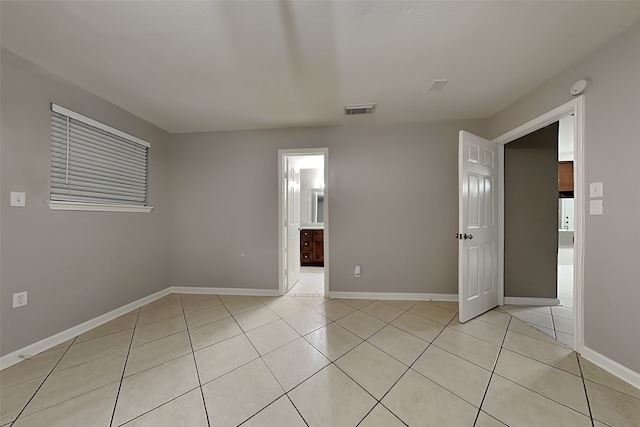 spare room featuring light tile patterned floors, baseboards, and visible vents