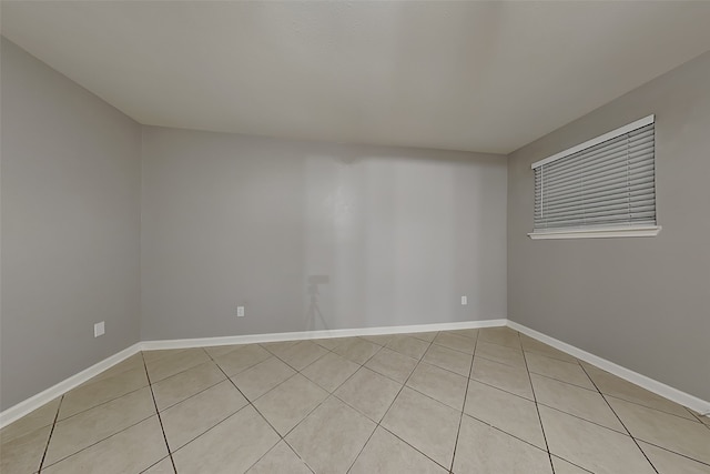 unfurnished room featuring light tile patterned floors and baseboards