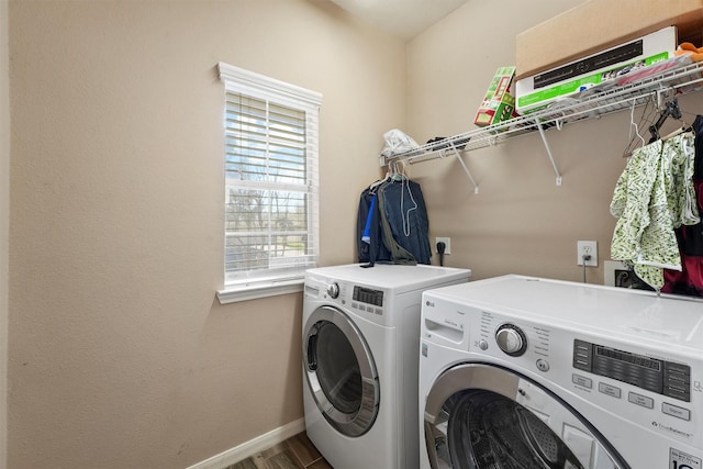 laundry room with laundry area, wood finished floors, baseboards, and washing machine and clothes dryer