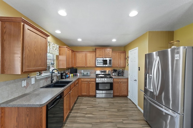 kitchen featuring recessed lighting, brown cabinets, appliances with stainless steel finishes, and a sink