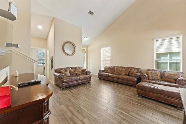 living room with a wealth of natural light, visible vents, and wood finished floors