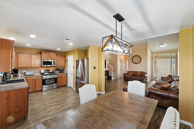 kitchen featuring visible vents, stainless steel appliances, wood finished floors, and a sink