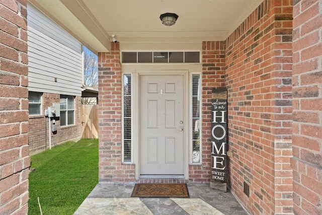 property entrance featuring brick siding