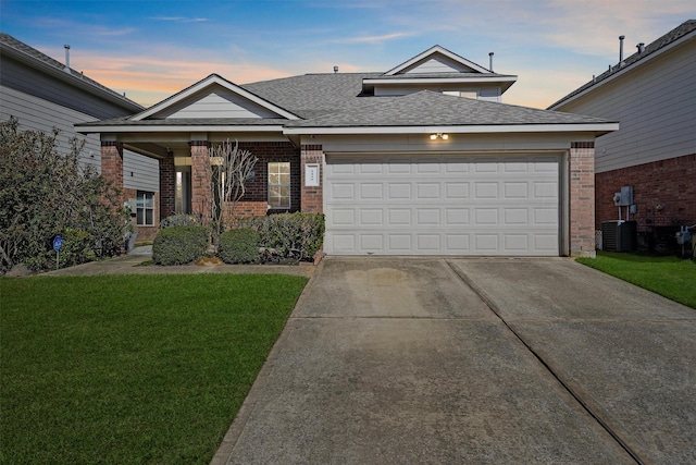 view of front of property with a garage, driveway, brick siding, and a front lawn