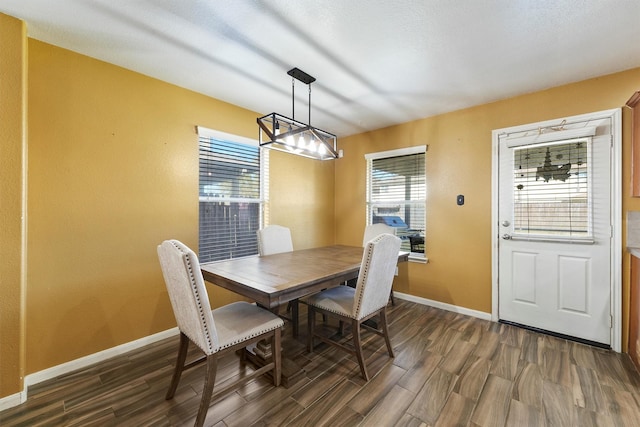 dining space featuring dark wood finished floors and baseboards