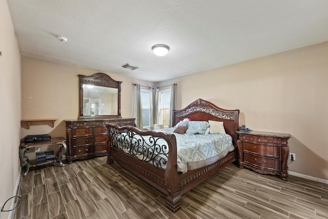 bedroom featuring baseboards, visible vents, and wood finish floors