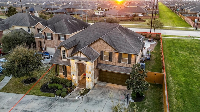 view of front of property featuring a residential view, roof with shingles, and an attached garage