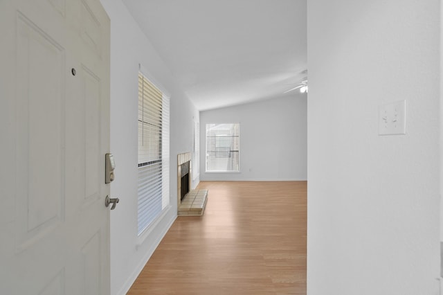 hallway featuring baseboards and light wood finished floors