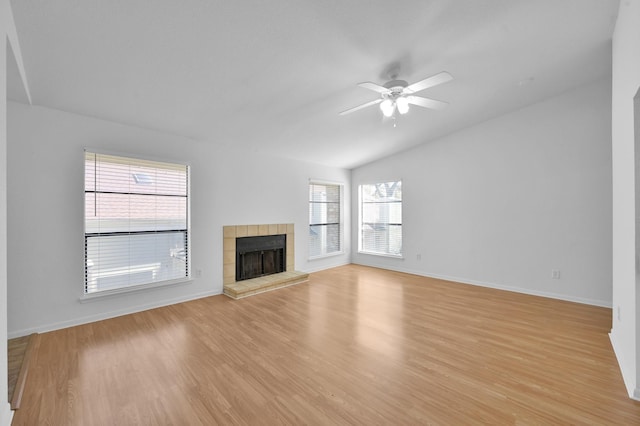 unfurnished living room with light wood-type flooring, a ceiling fan, a fireplace, and vaulted ceiling