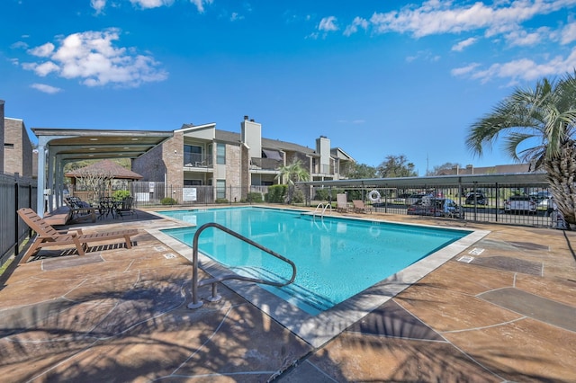 community pool featuring a patio area and fence